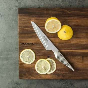 GS-92 Cooks Knife 13cm Fluted cutting lemons on GLOBAL Walnut Chopping Board