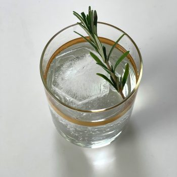 DrinksPlinks Shape Statement Hexagon in gold rimmed glass with rosemary