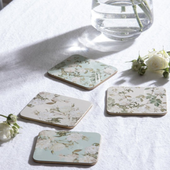 Four of Ashdene's Elegant Rose Coasters on a white table cloth.