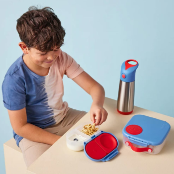 Lifestyle image on B.Box Snackbox Blue Blaze on a table with matching drink bottle and lunchbox.