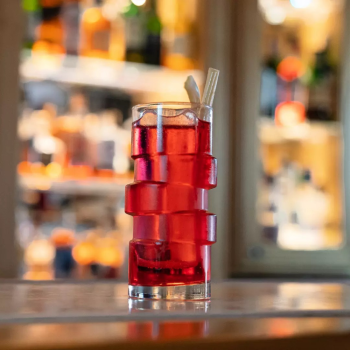Glitch Collins on a bar top with red cocktail