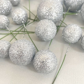 20 Silver Ball Decorations in a pile on a grey background.